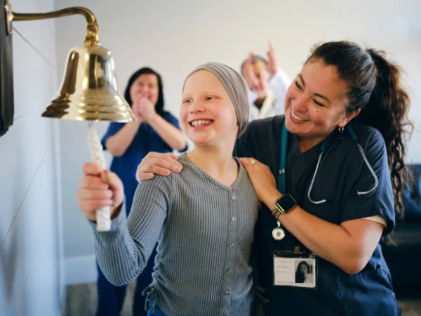 A child ringing the bell at the end of cancer treatment